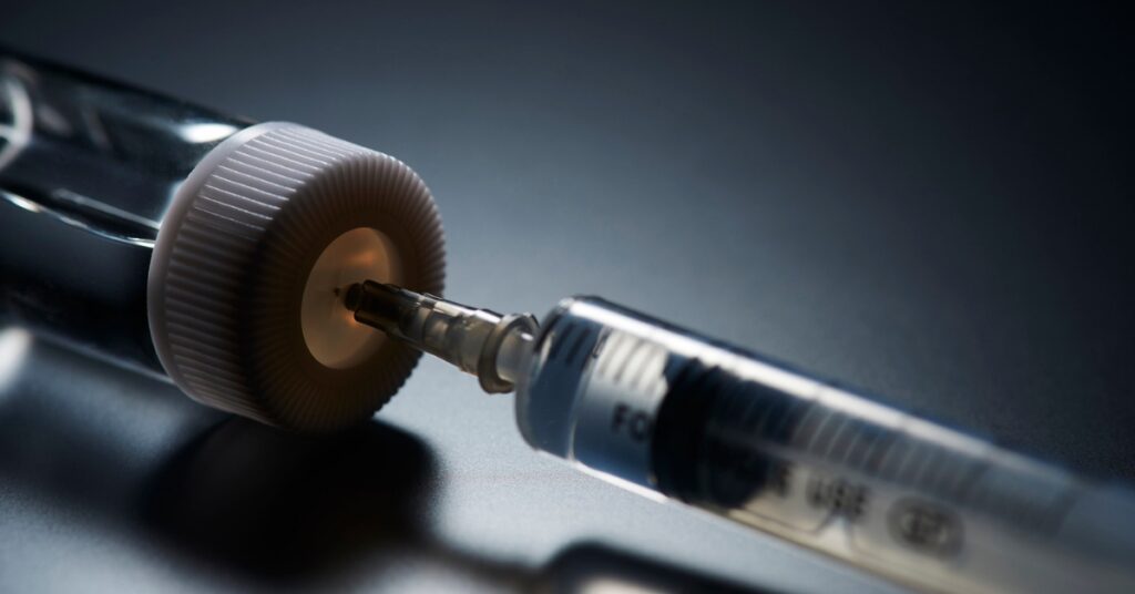 Prescription peptide vial and injection syringe representing provider-guided peptide therapy
