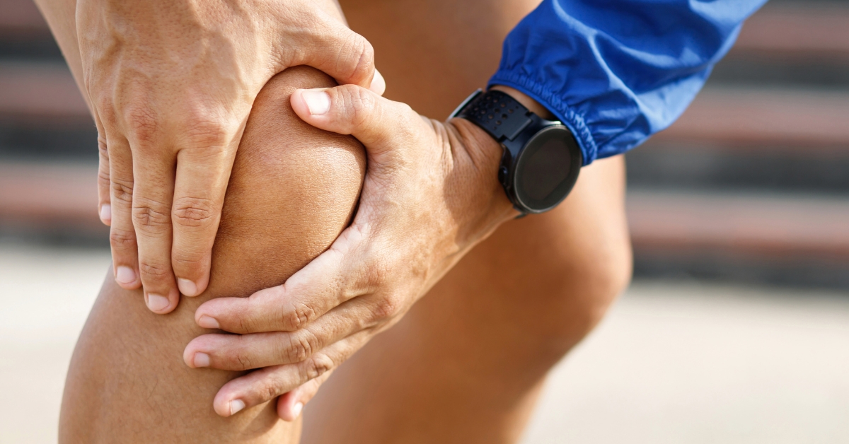 man holding knee due to joint pain considering TRT treatment