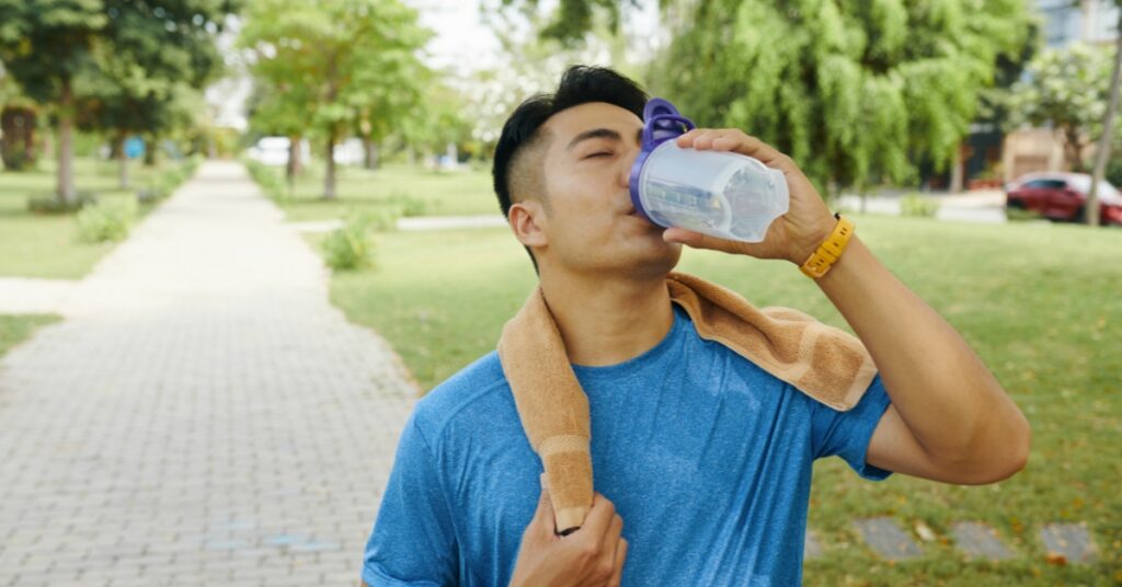 A man holding his stomach to illustrate common symptoms like bloating or fluid retention that may occur when starting testosterone replacement therapy (TRT).