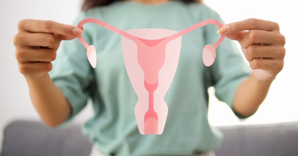 Woman holding an anatomical uterus model to represent polycystic ovary syndrome (PCOS) and reproductive hormone health