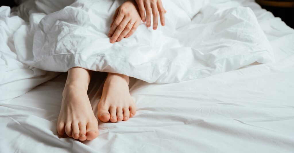 Woman sitting in bed looking frustrated and emotionally distant, representing low libido and intimacy challenges associated with PCOS