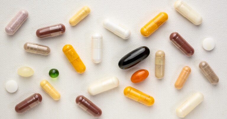 Assortment of vitamin capsules and supplements arranged on a table, representing nutritional support and vitamin supplementation