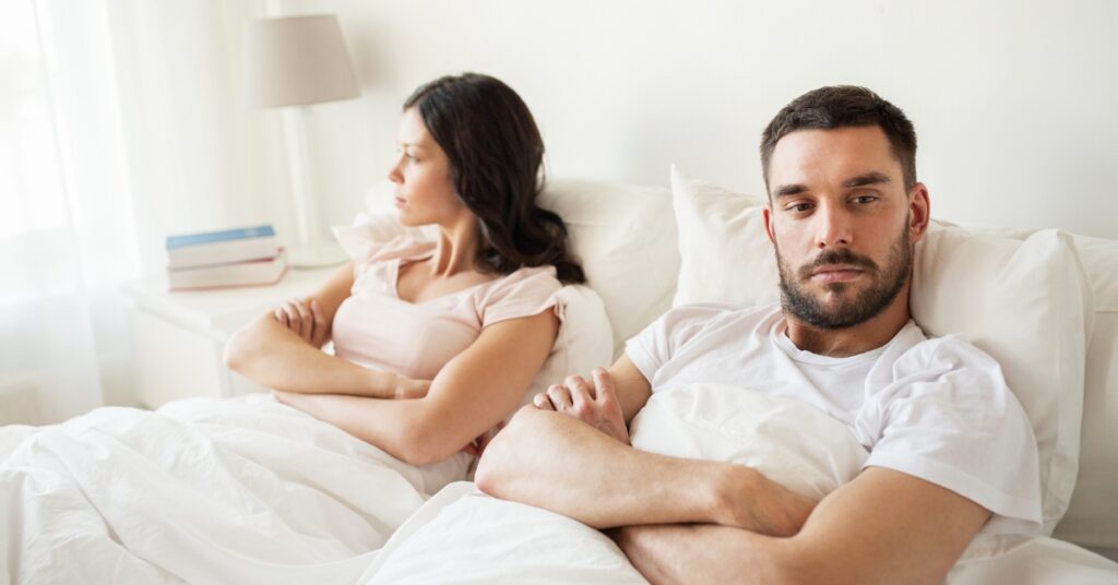 Unhappy couple sitting apart, illustrating low libido and relationship challenges associated with low testosterone