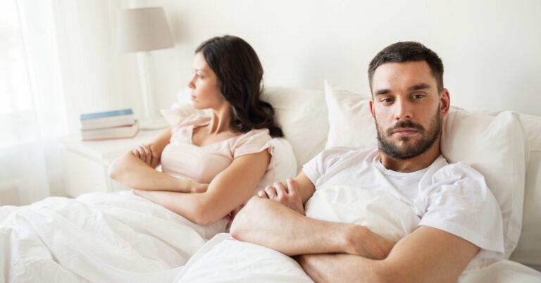 Unhappy couple sitting apart, illustrating low libido and relationship challenges associated with low testosterone
