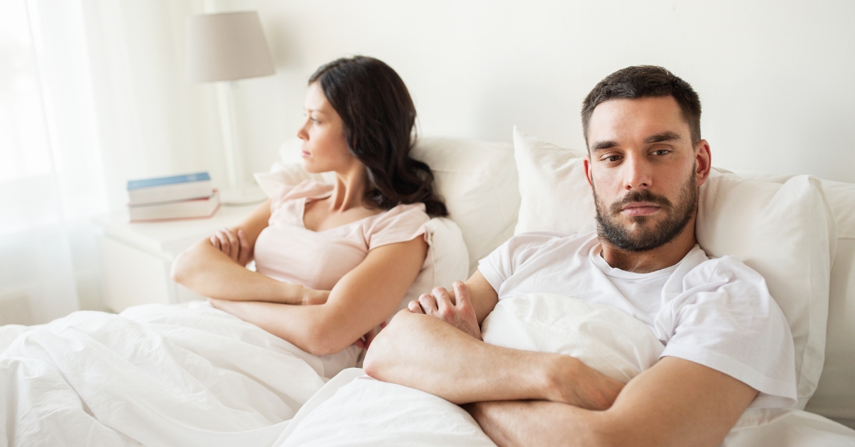 Unhappy couple sitting apart, illustrating low libido and relationship challenges associated with low testosterone
