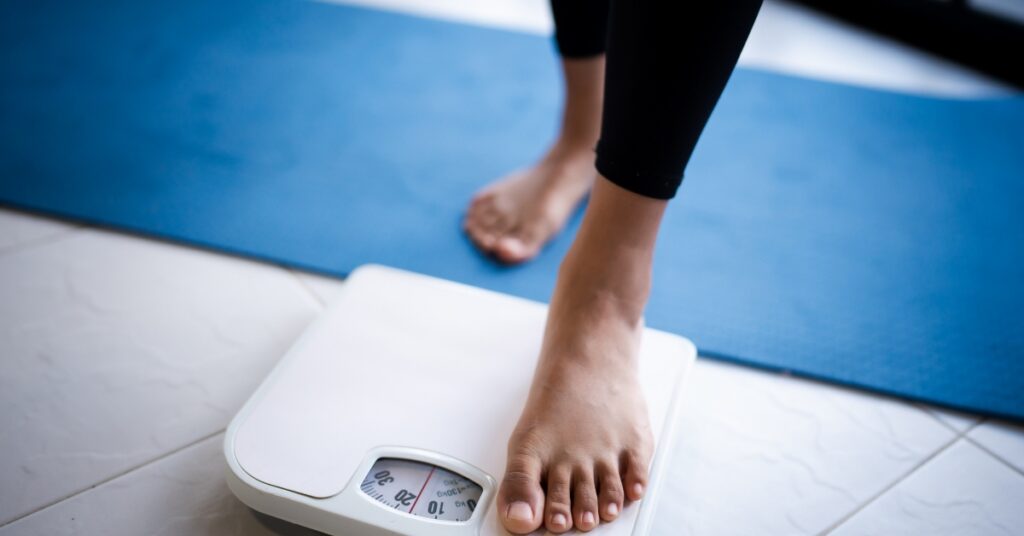 Person standing on a bathroom scale as part of a medical weight management journey.