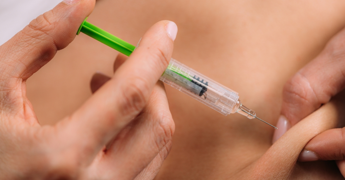 Person self-administering an injection as part of a prescribed treatment plan.