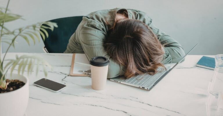 Stressed woman resting her head face down on a desk
