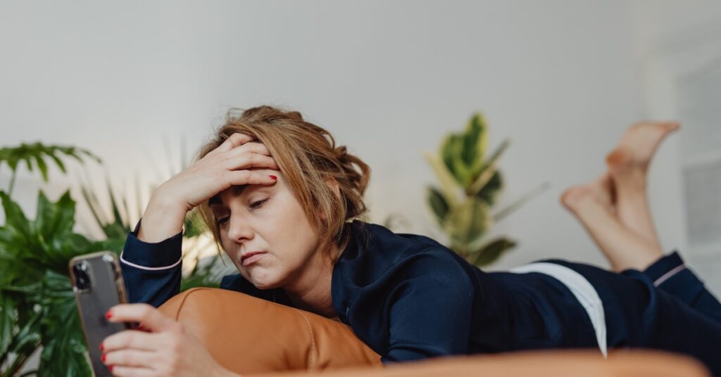 Stressed woman sitting on a couch with a worried expression