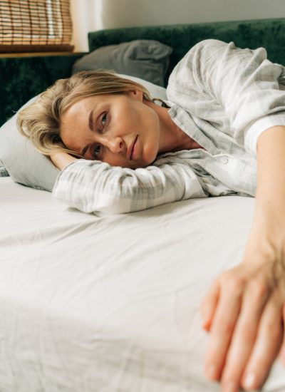 Beautiful blonde woman in pajamas on the bed in the morning after waking up.
