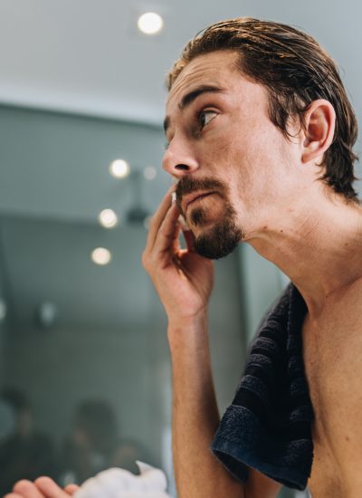 Mid adult man applying shaving foam on his face in the bathroom at home