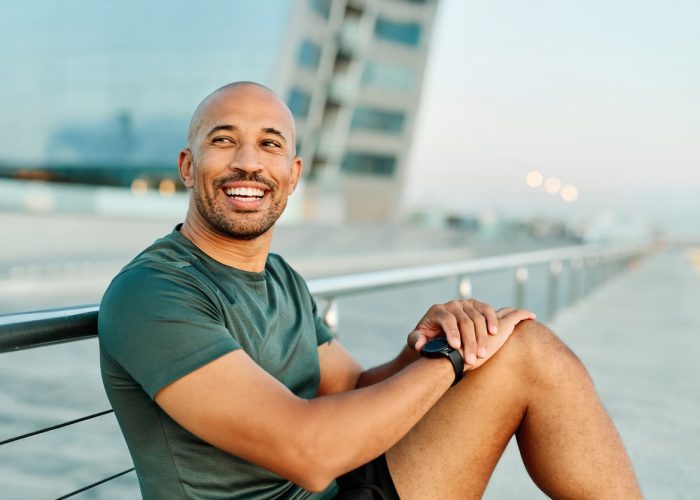 Portrait opf a young man prepering to exercise and looking at watch in sportwear posing for a portrait outdoors